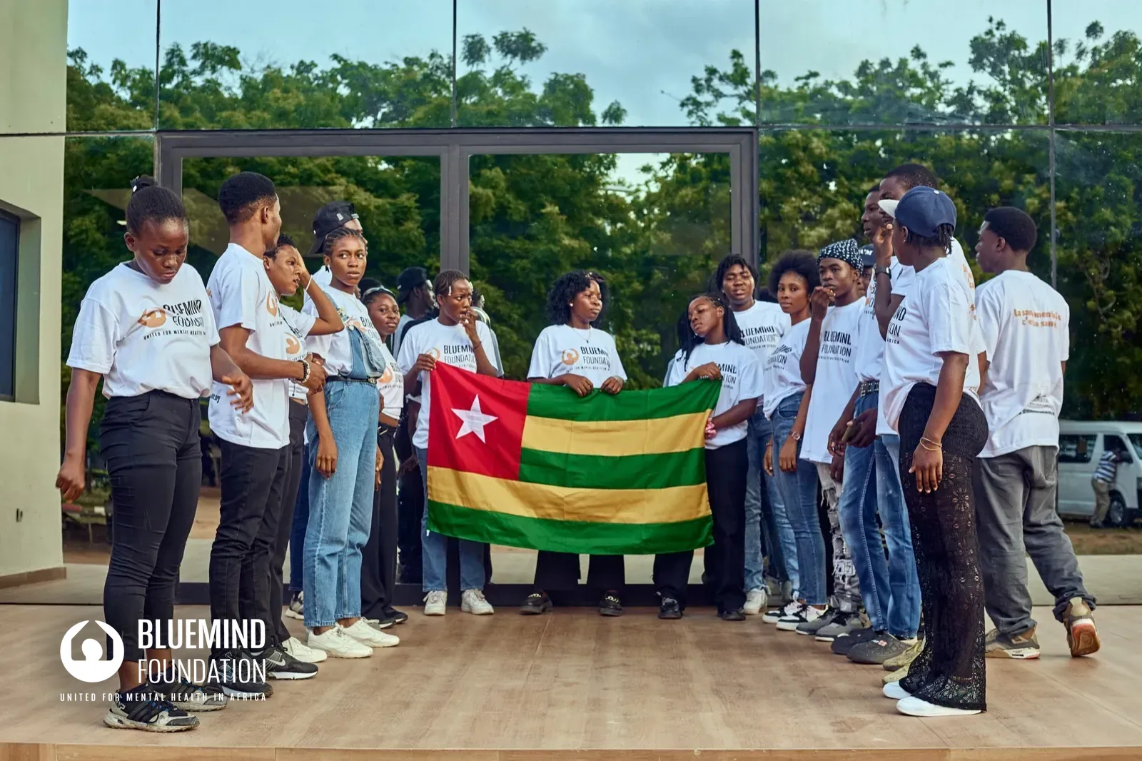Jeunes ambassadeur⋅rice⋅s réuni⋅e⋅s autour du drapeau du Togo pendant l'Ubunt' Blue Week.